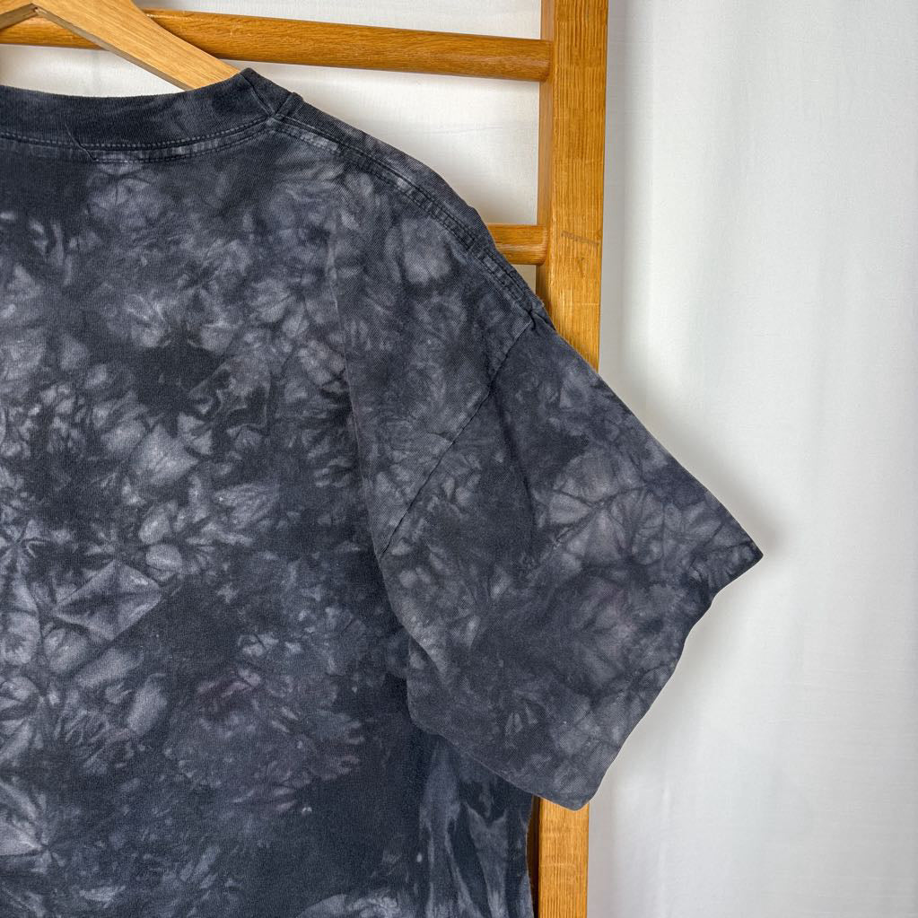 A dark gray tie-dye short sleeve t-shirt on a wooden rack against a white background.
