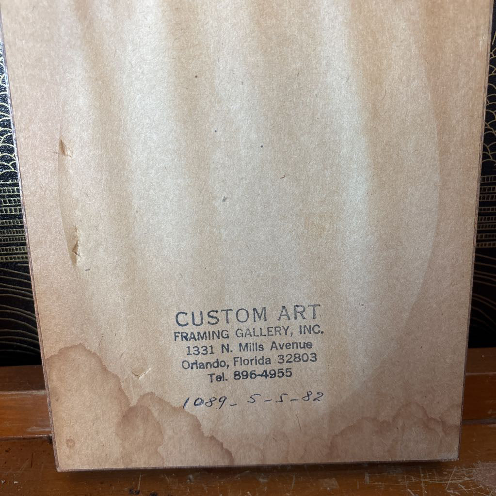 The back of a cross-stitch artwork showing where it was framed and when it was made.