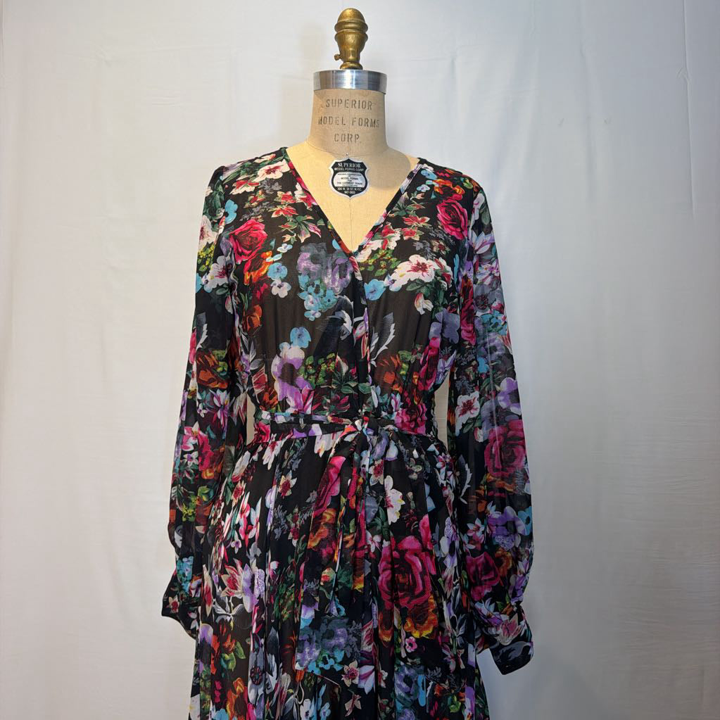 A floral maxi dress on a mannequin in front of a white wall.