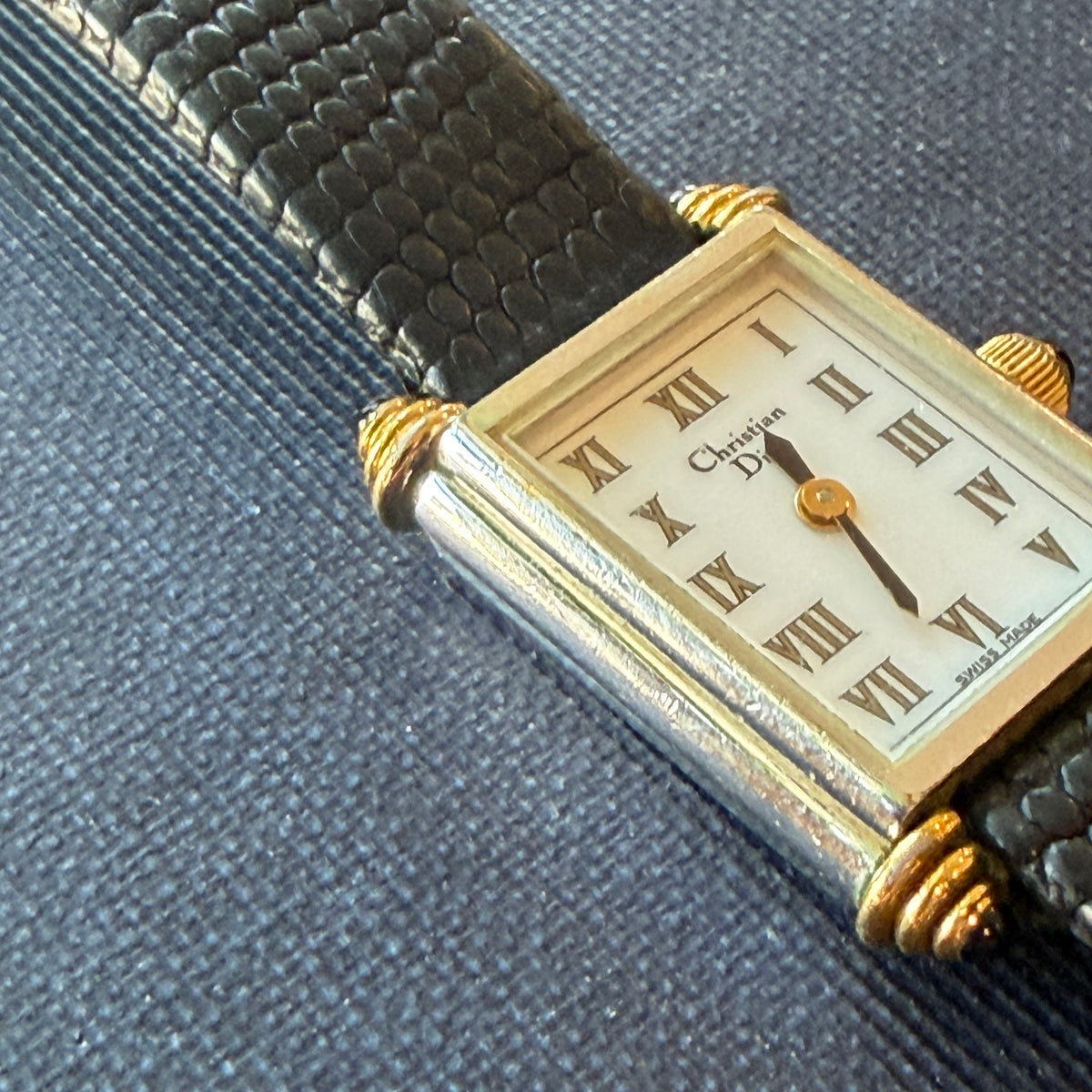 Close up of the face of a Vintage Christian Dior Tank Watch showing the gold and silver around the face
