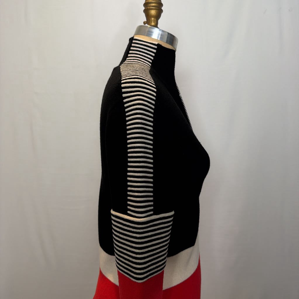 A black, red, and white color block zip-up jacket on a mannequin in front of a white wall.