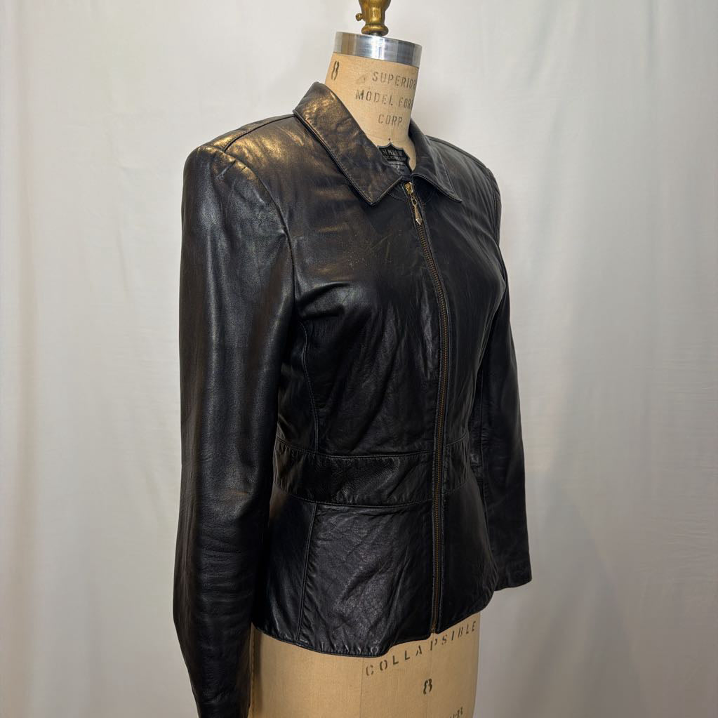 A black zip-up leather jacket on a mannequin in front of a white wall.
