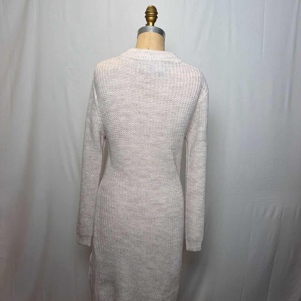 A white knit dress with an open neck and a slit on the bottom. It's on a mannequin in front of a white wall.