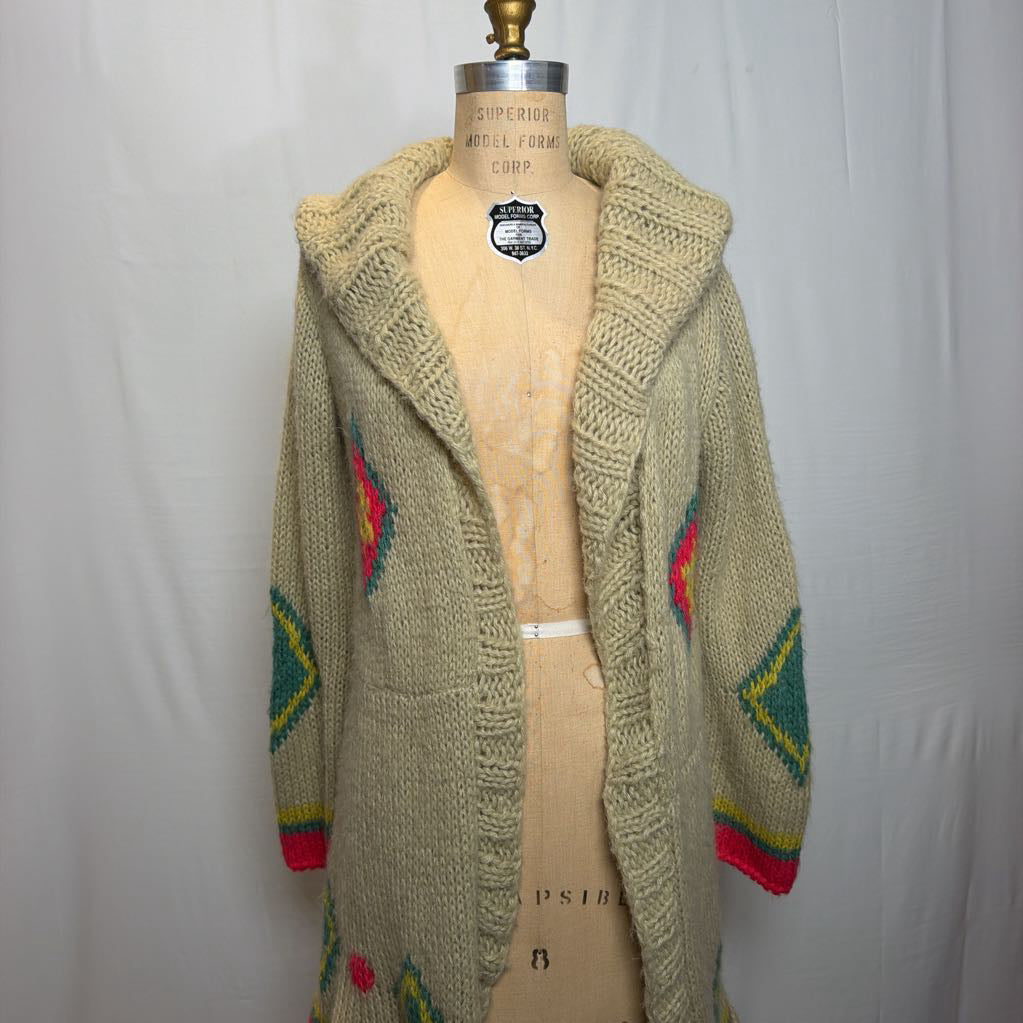 A tan belted knit sweater hoodie on a mannequin in front of a white wall.