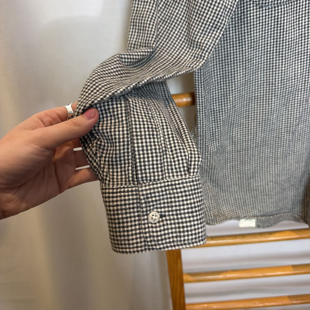 A button-up shirt on a wooden rack.