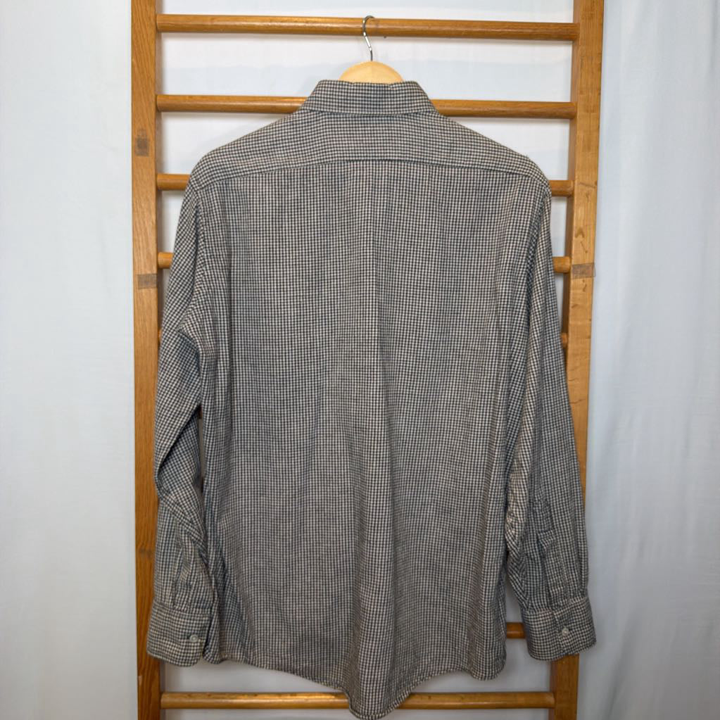 A button-up shirt on a wooden rack.