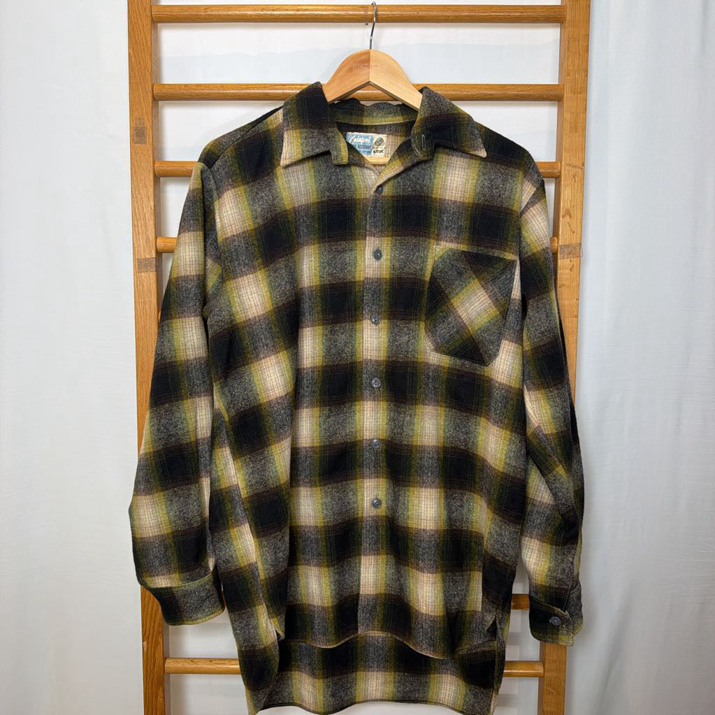 A green ombre plaid button-up shirt on a wooden rack.