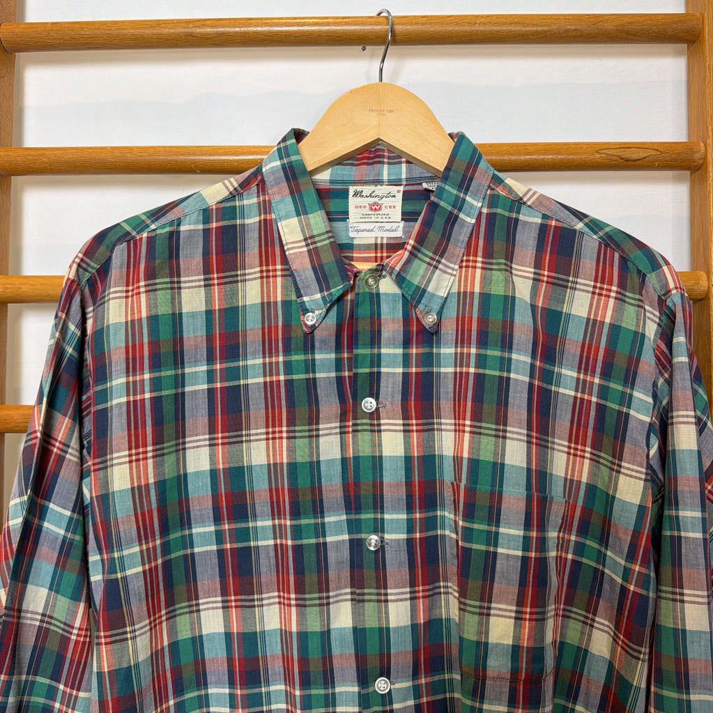 A plaid button-up shirt on a wooden rack.