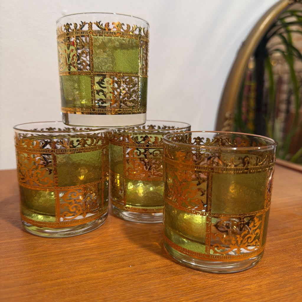Four culver prado green glassware featuring a pale green tine and ornate 22k gold filigree checkerboard panels sitting on wood.