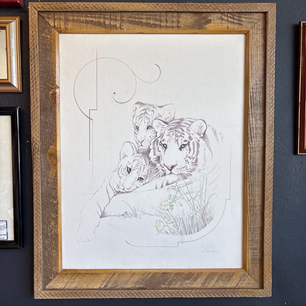 A white artwork of a tiger and cubs in a thick wooden frame.