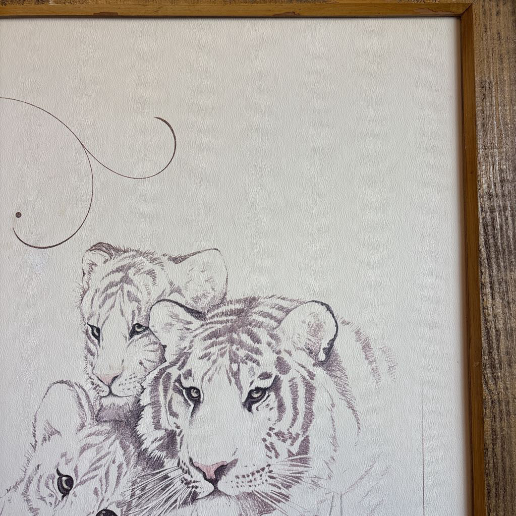 A white artwork of a tiger and cubs in a thick wooden frame.