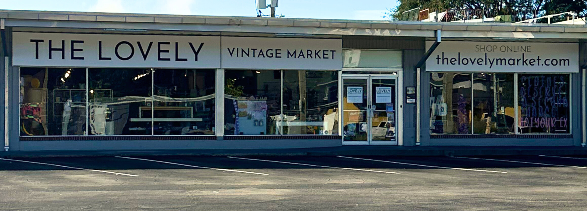 storefront of The Lovely Vintage Market with large windows and visible branding.