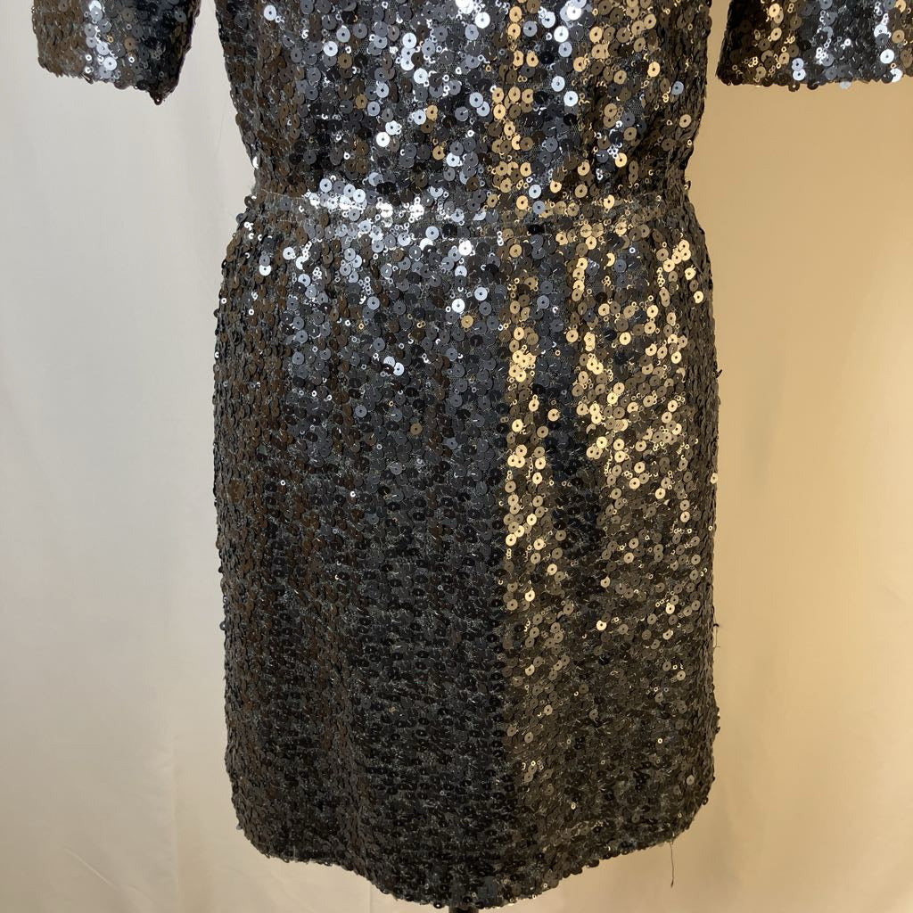 Black sequin dress on a mannequin against a neutral background