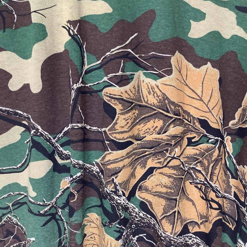 Camouflage pattern with leaves and branches on a fabric background