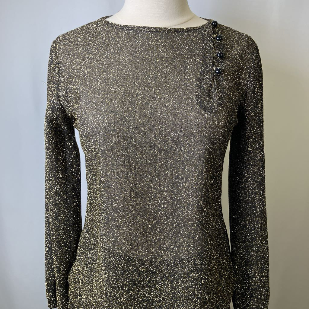 Mannequin wearing a long-sleeve, sparkly top with button details on a plain background