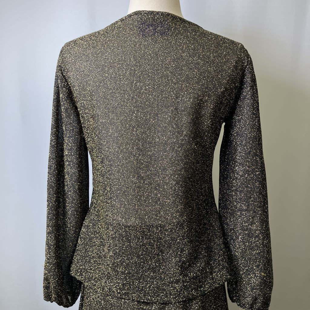 Mannequin wearing a long-sleeve, speckled top against a plain background