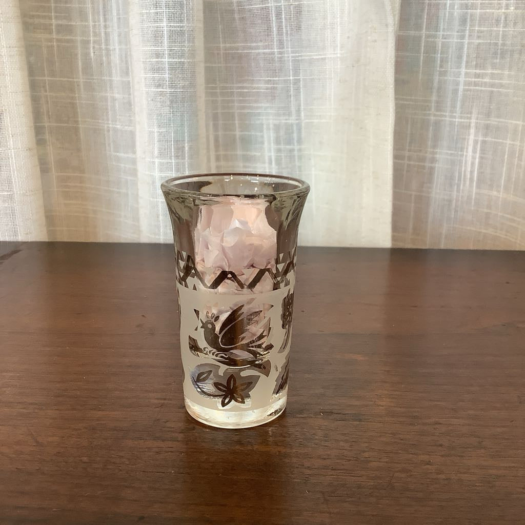 Decorative glass with floral patterns on a wooden surface