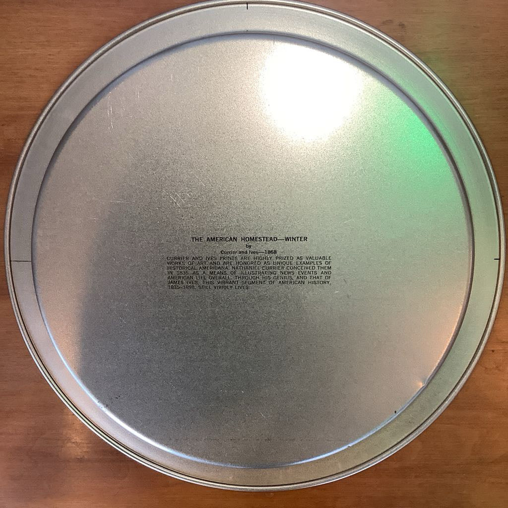 Metallic lid with text on a wooden surface