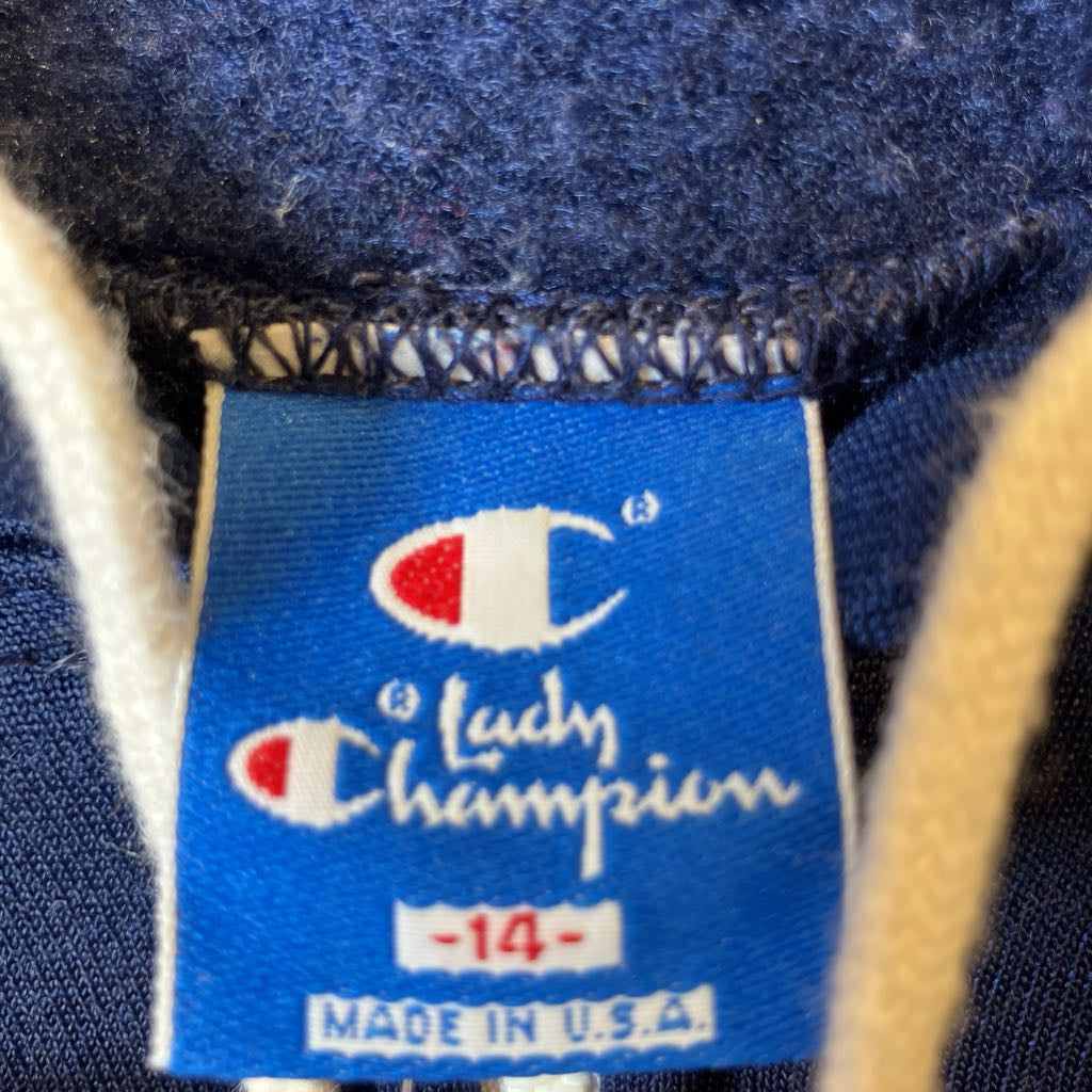 Close-up of a Champion brand label on a blue fabric background
