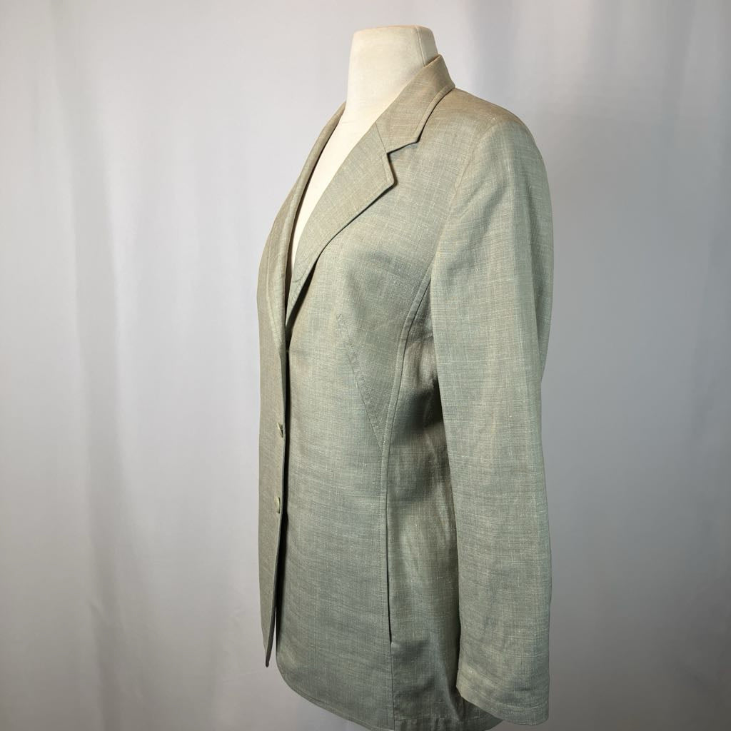 Green blazer on a mannequin against a plain background