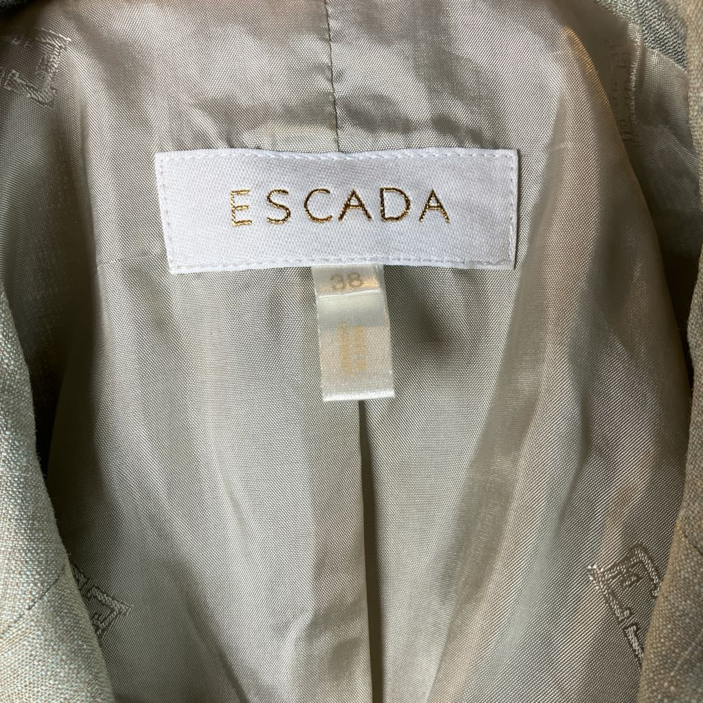 Close-up of a beige jacket with an Escada label on a light background