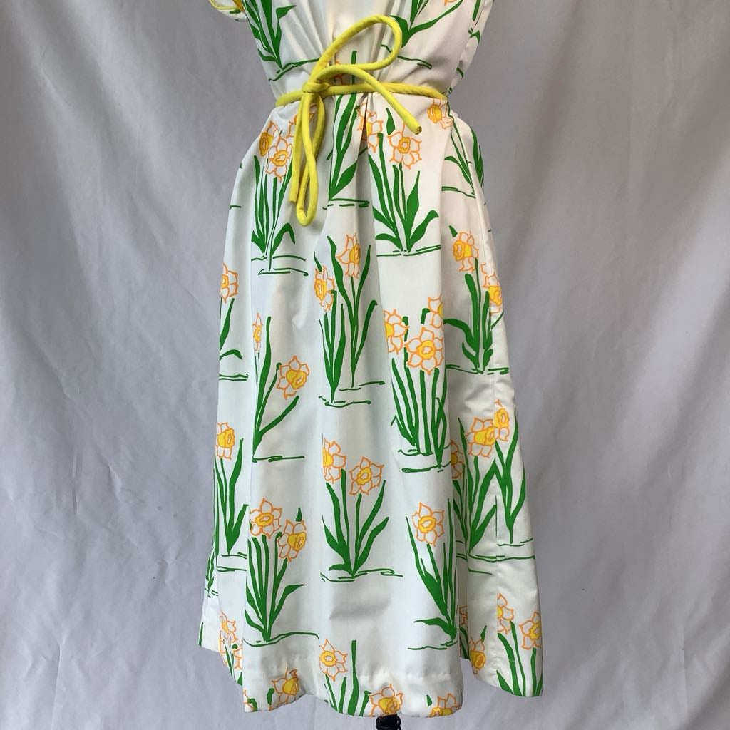 Floral dress with yellow flowers and green leaves on a white background