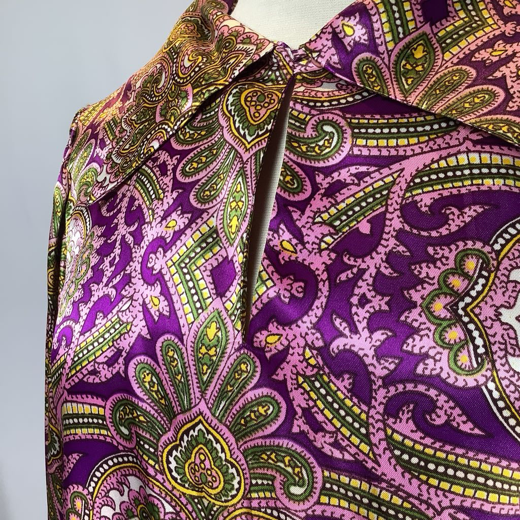 Close-up of a purple fabric with green and yellow paisley pattern