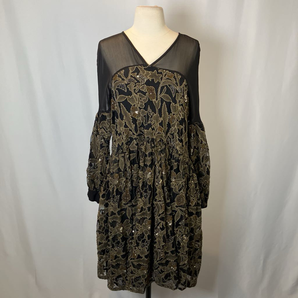 Black lace dress on a mannequin against a plain background