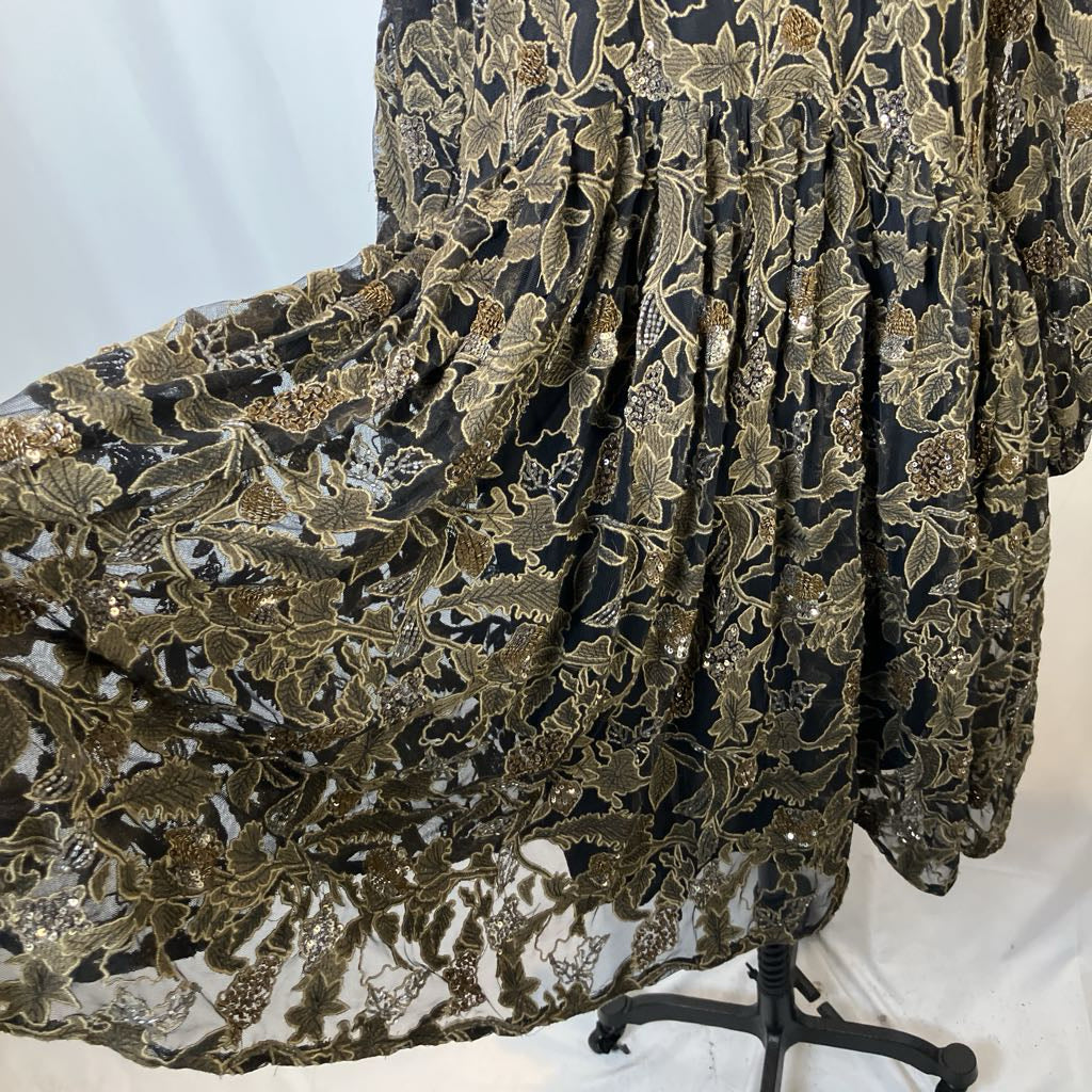 Black and gold floral embroidered fabric on a mannequin against a white background