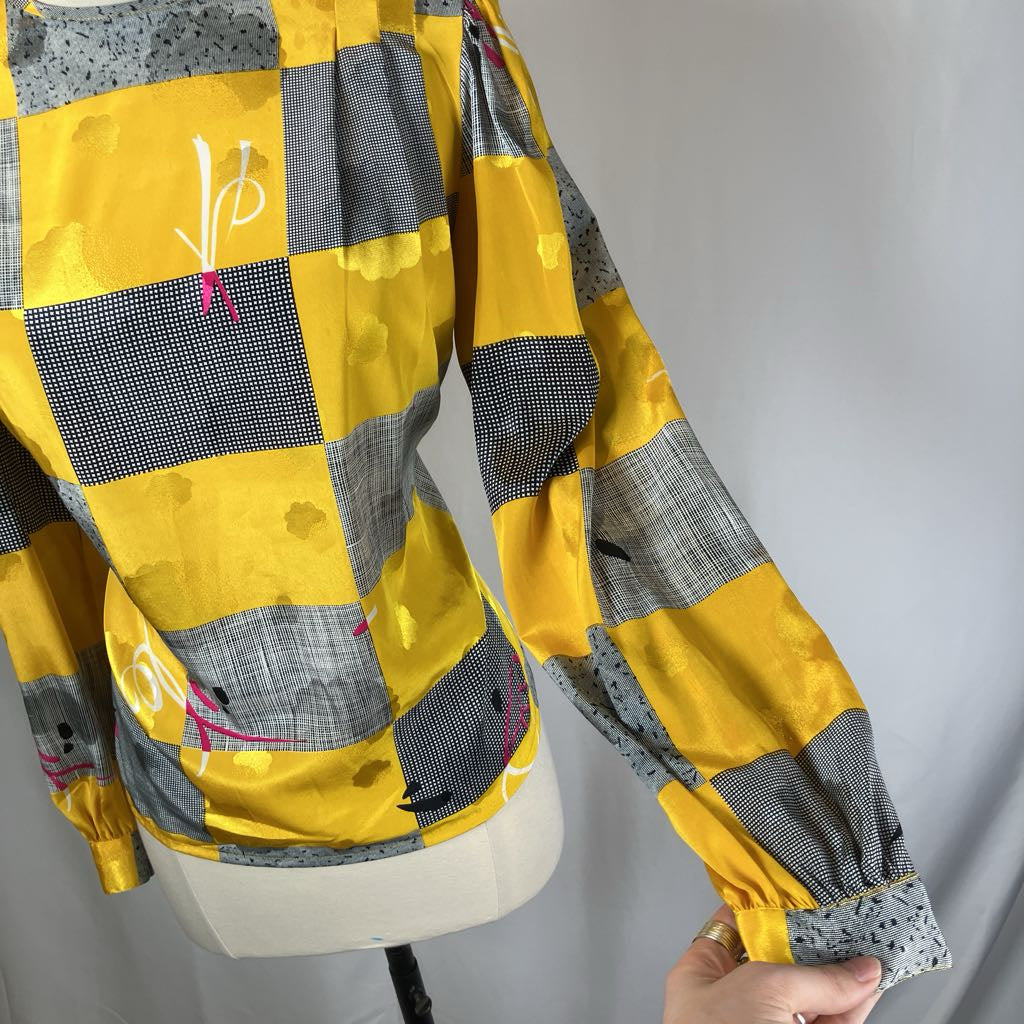 Yellow and gray checkered jacket on a mannequin against a plain background
