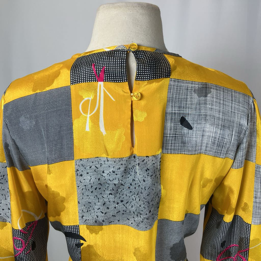 Yellow and gray patchwork jacket on a mannequin against a plain background