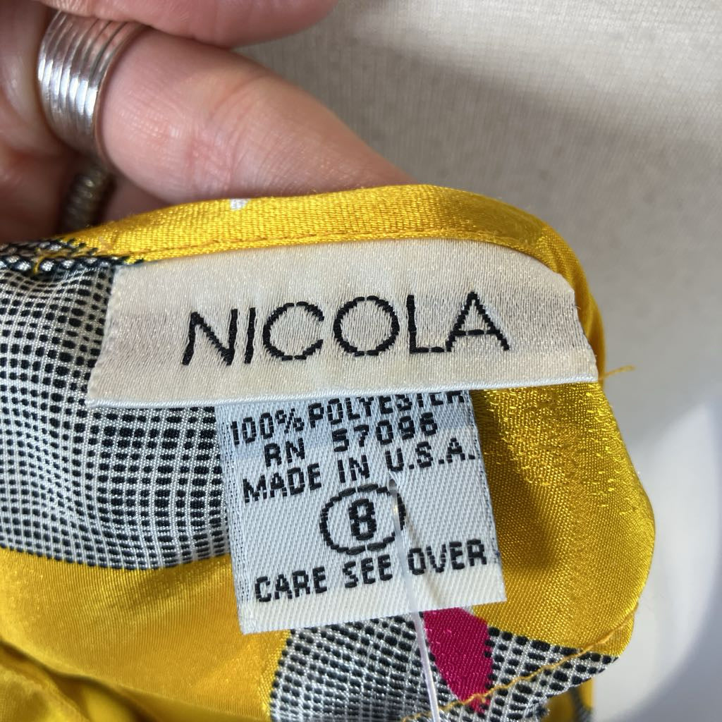 Close-up of a 'Nicola' label on fabric with text and a pattern.