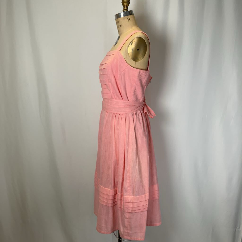 Pink dress on a mannequin against a plain background
