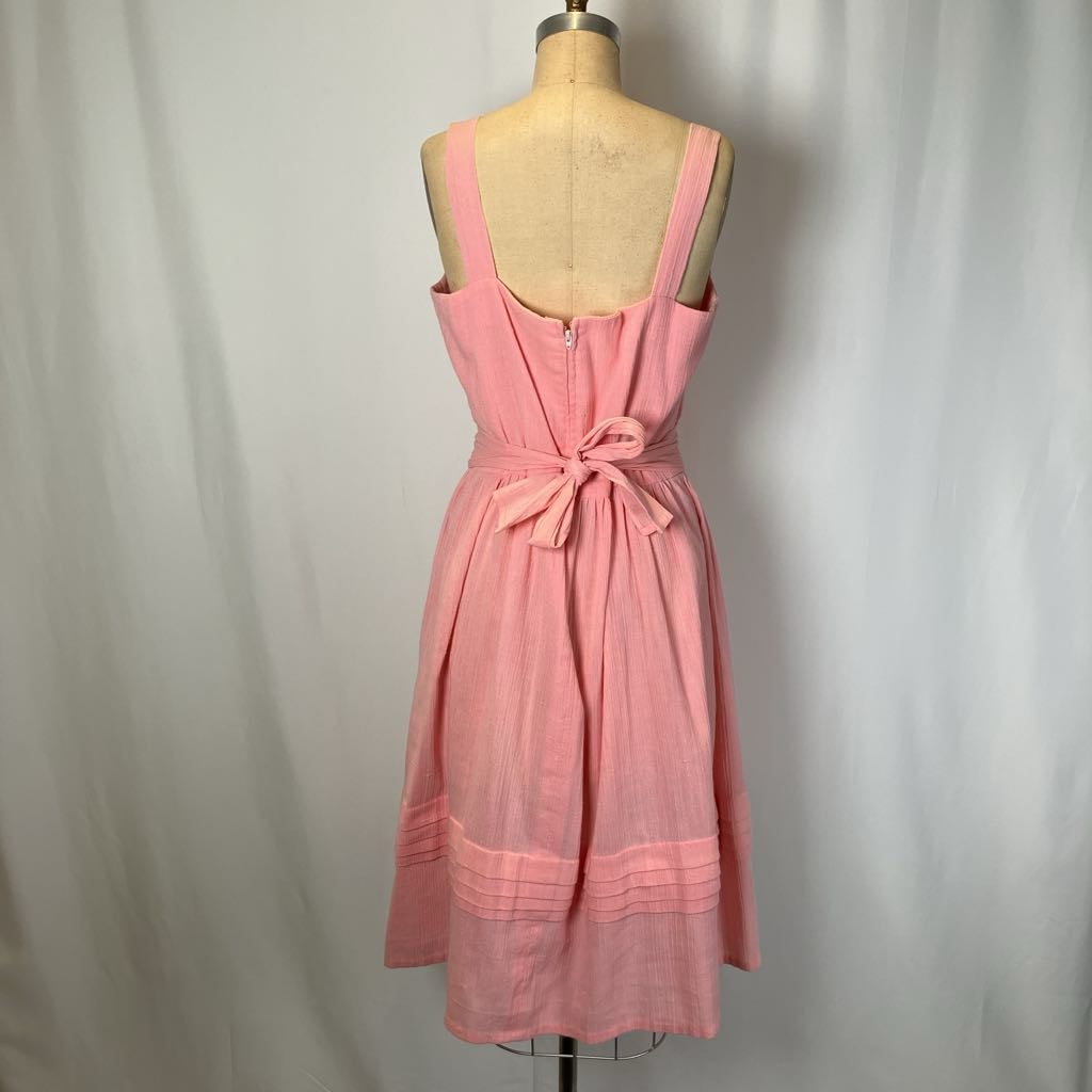 Pink dress on a mannequin against a plain background