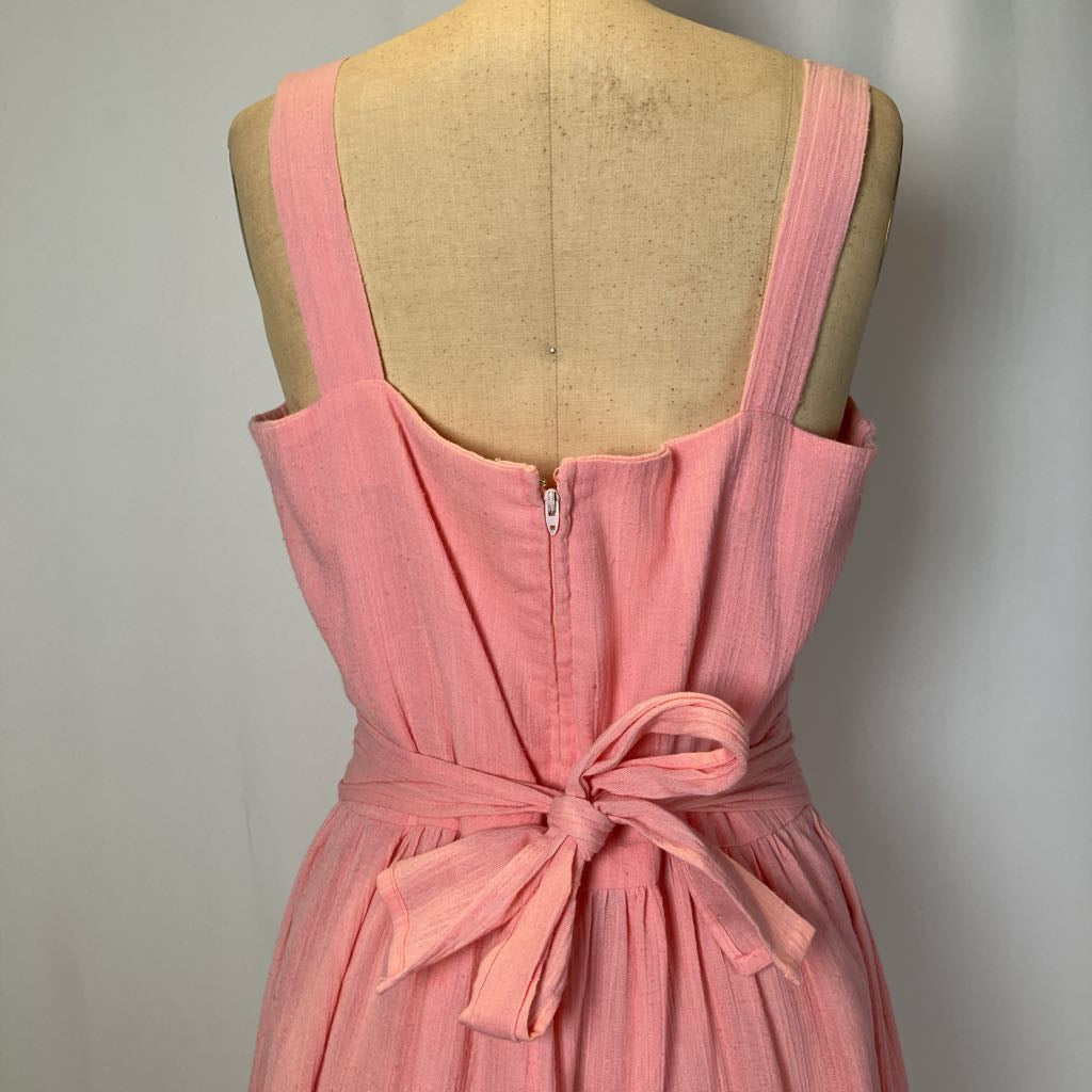 Pink dress on a mannequin with a plain background