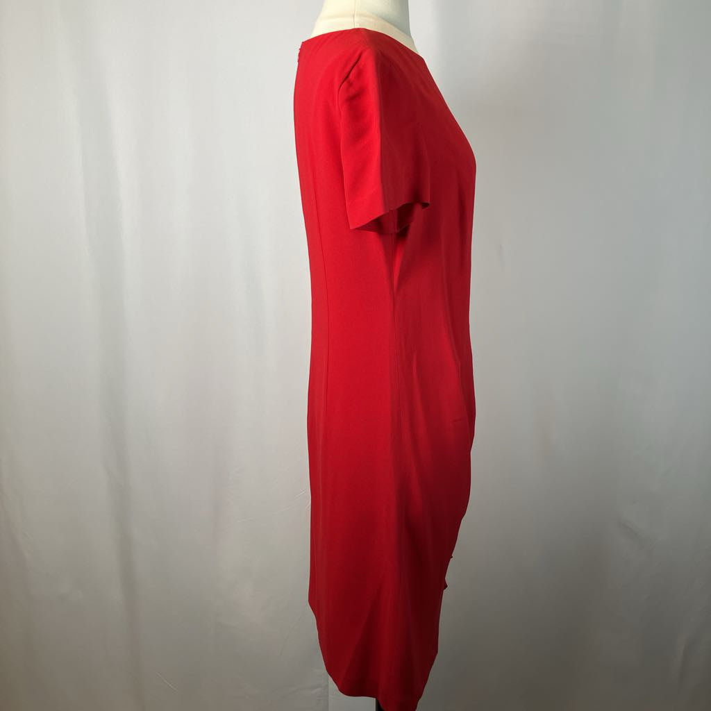 Red dress on a mannequin against a plain background