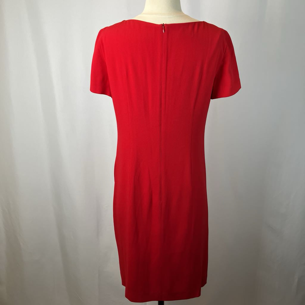 Red dress on a mannequin against a plain background