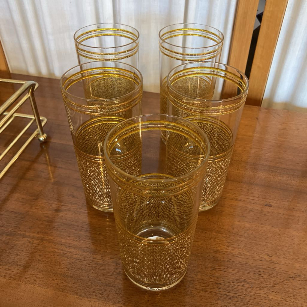 Set of gold embossed glasses on a wooden surface