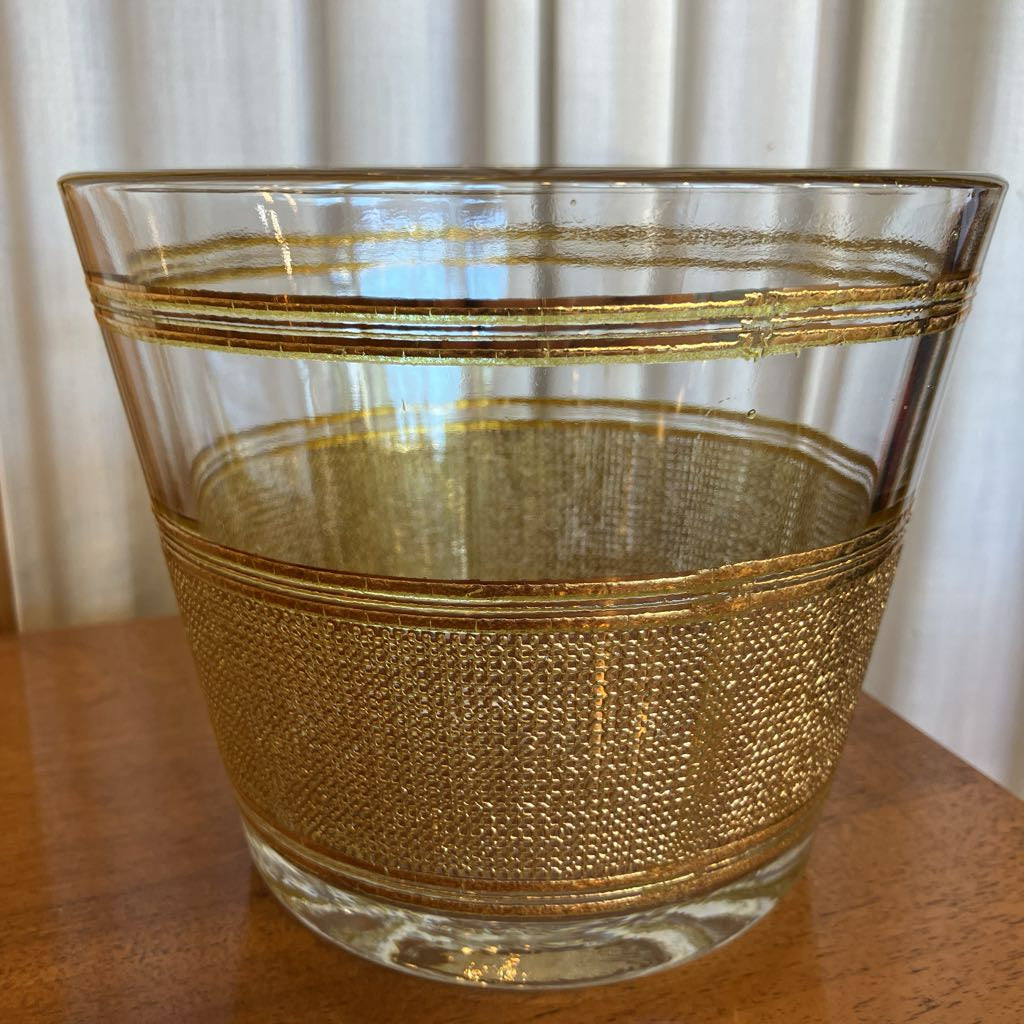 Up close shot of gold embossed ice bucket on a wooden surface