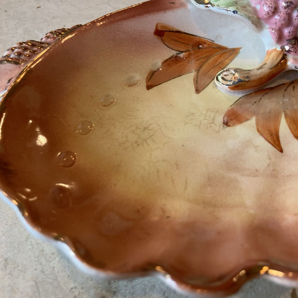 Close-up of a decorative ceramic dish with floral design and gold accents.