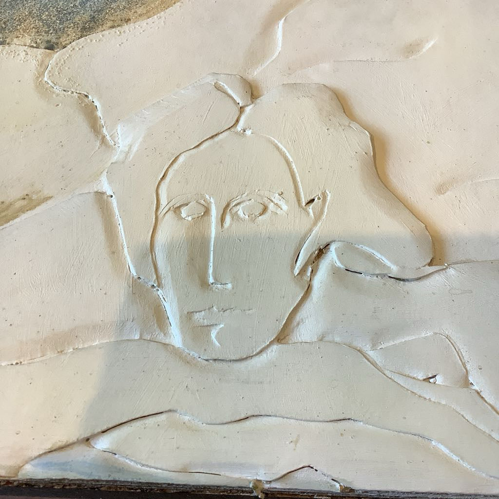 Abstract sculpture of a woman's face and shoulders in beige material