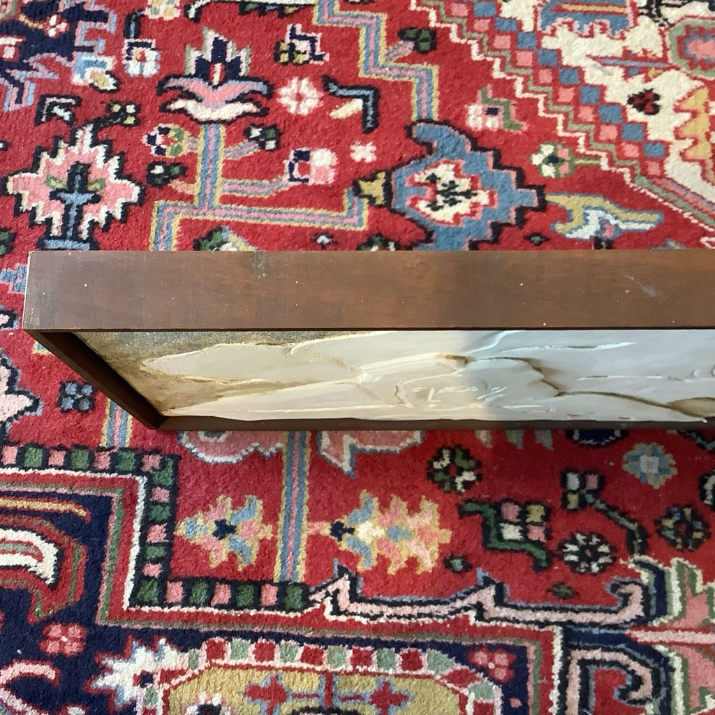 Decorative wooden box with white floral design on a red patterned rug