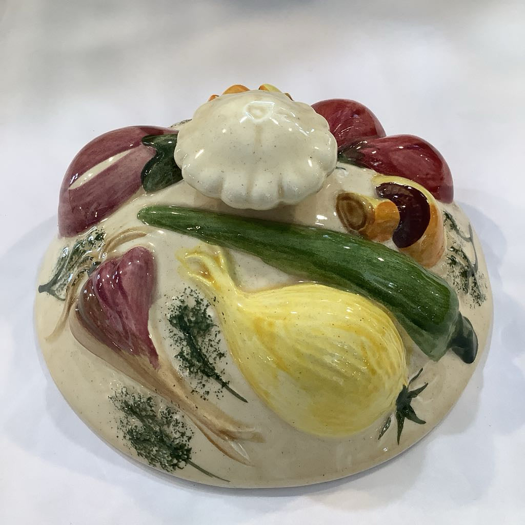 Decorative ceramic lid with vegetables on a white background