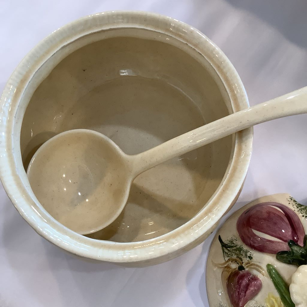Ceramic bowl with a spoon on a white surface.