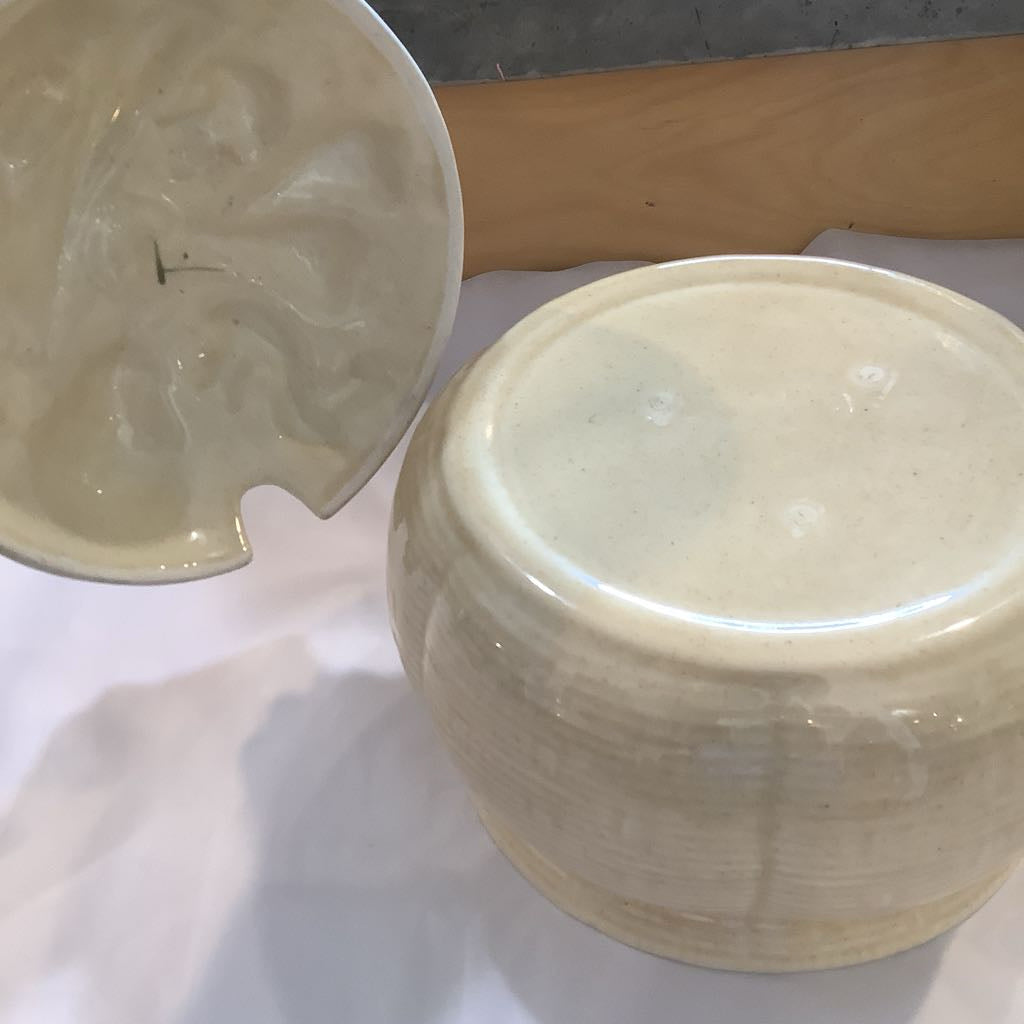 White ceramic jar with lid on a white surface