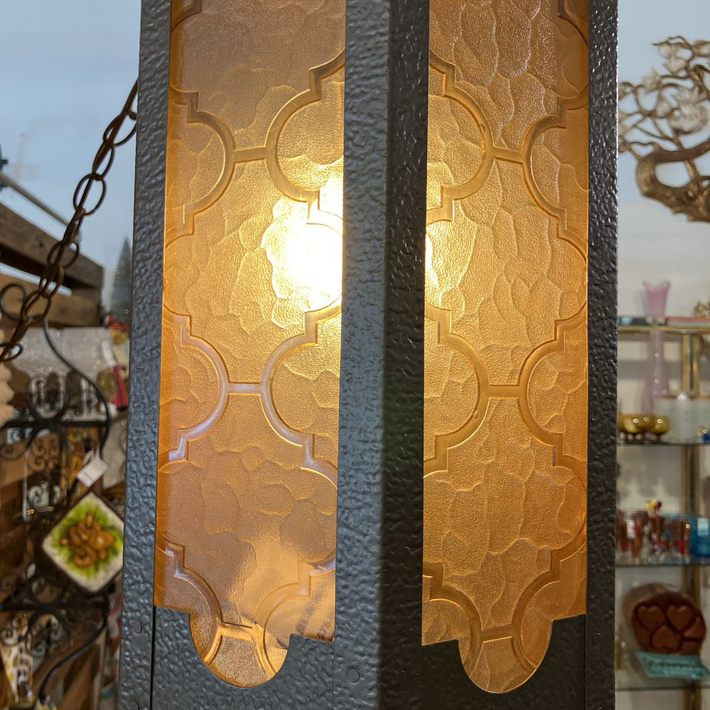 Decorative wall light fixture with intricate patterns on a blurred background