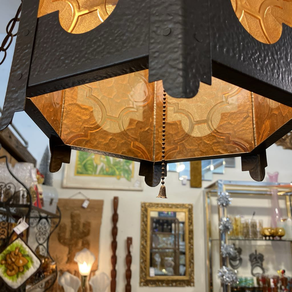 Decorative hanging light fixture with intricate design in a store setting