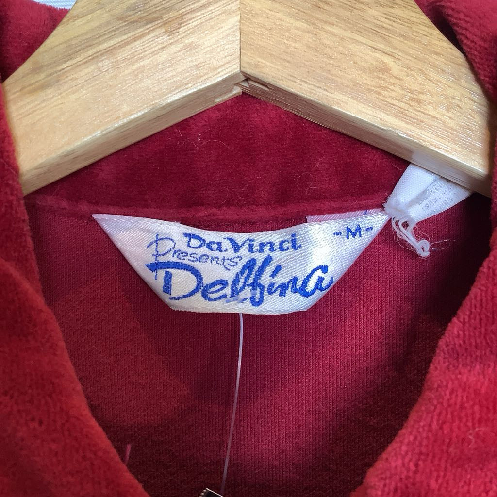 Red garment with a visible label on a wooden hanger