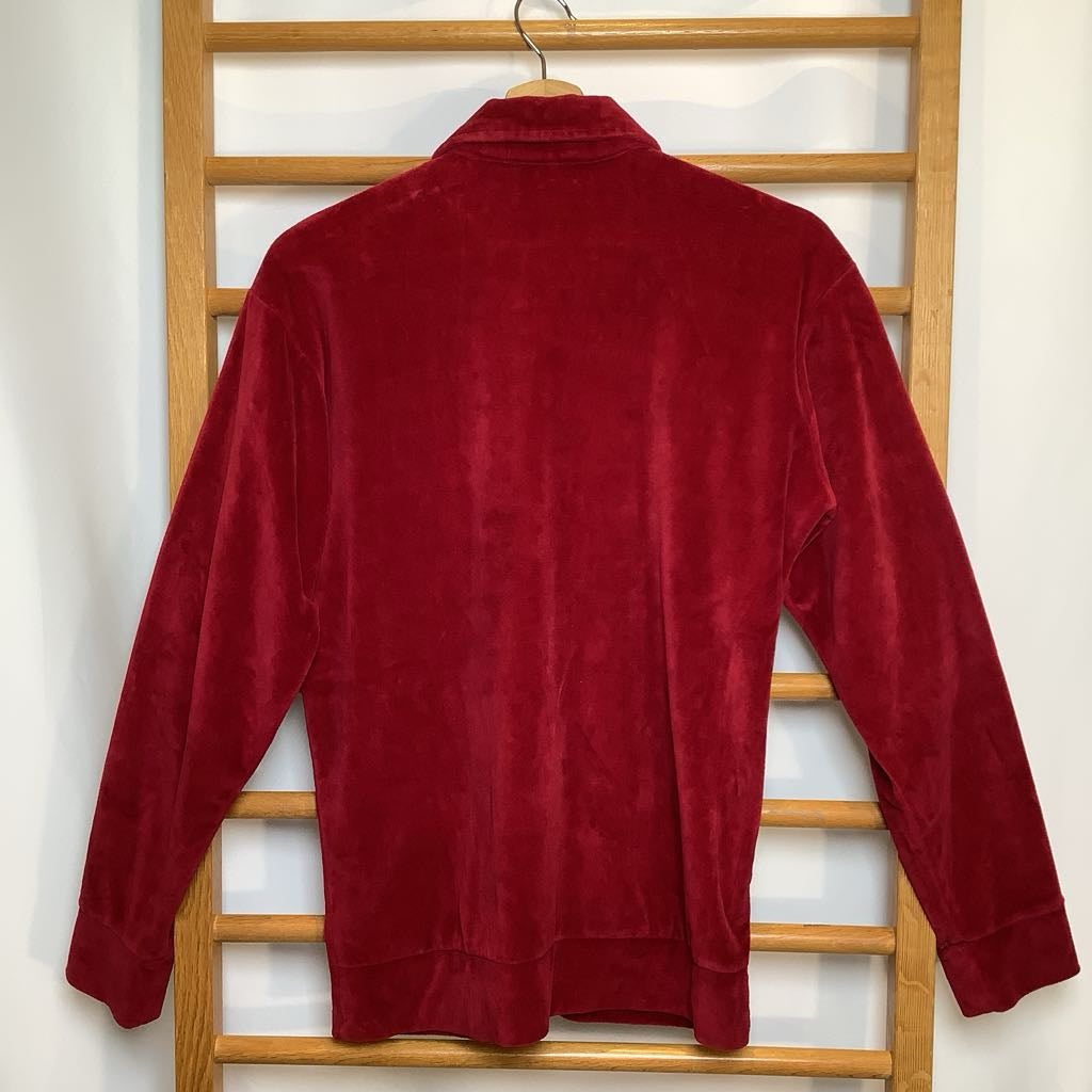 Red jacket on a wooden hanger against a white wall