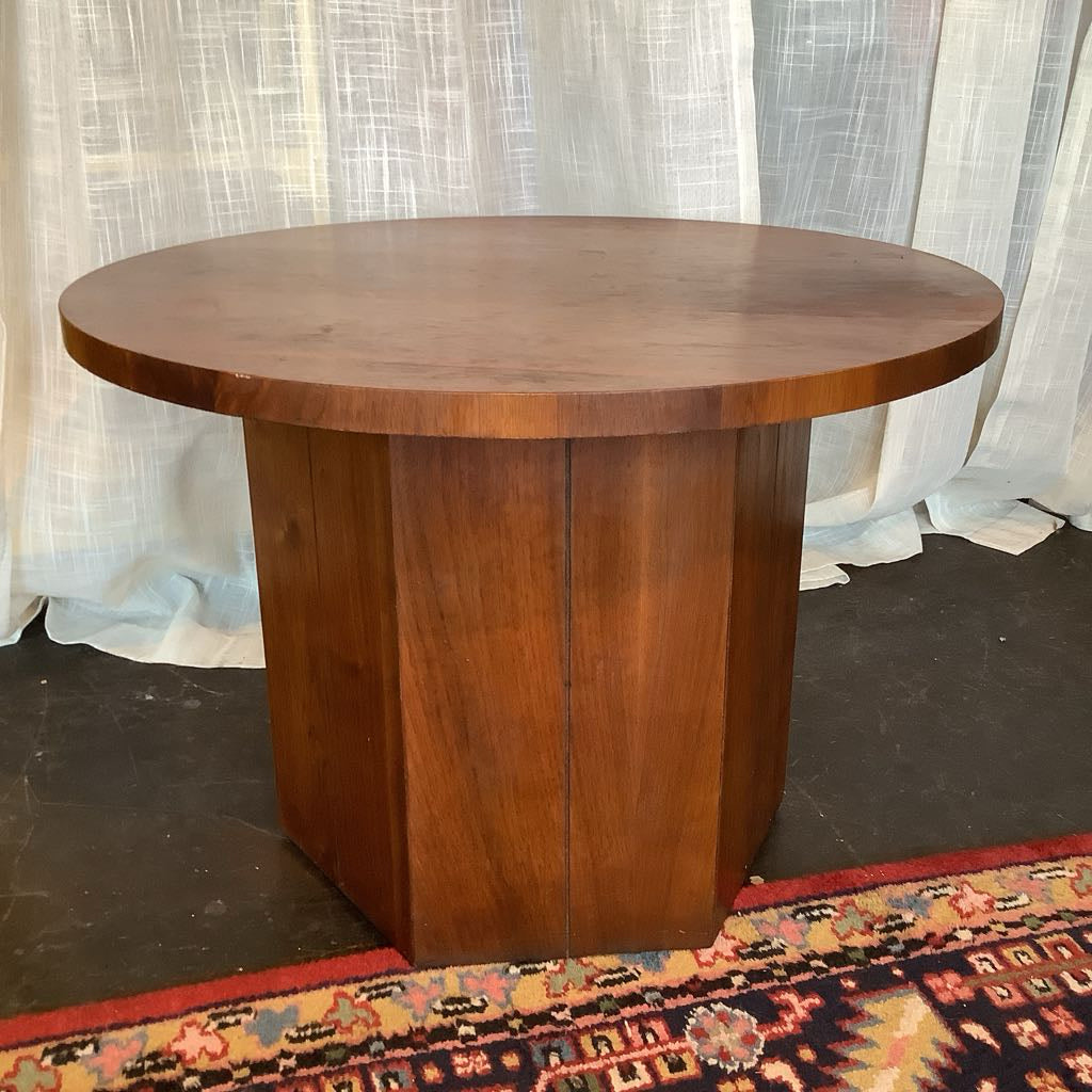 Wooden round table with a textured white curtain in the background